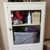 Value of an Aseptible Furniture Company Vintage Medical Cabinet - white metal cabinet with glass door and pull out bin
