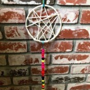 Dreamcatcher with Wooden Beads - dream catcher hanging against a brick wall