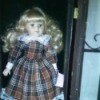 Value of a Ashley Bell Porcelain Doll - doll in black, brown, and white plaid dress