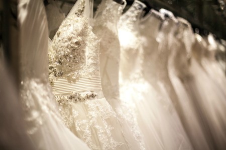 White wedding dresses hanging in a row.