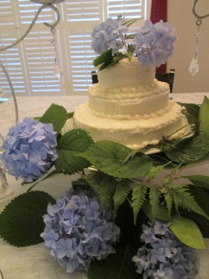 A wedding cake decorated with hydrangea blooms.