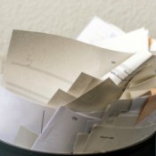A wastebasket filled with recycled paper.