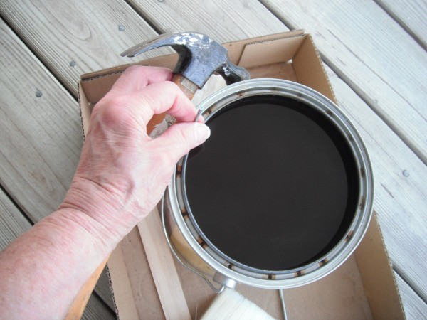 Holes poked around the can of paint or stain to allow it to drip down.