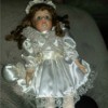 Identifying a Porcelain Doll - doll wearing a lace trimmed white satin dress with matching drawstring bag