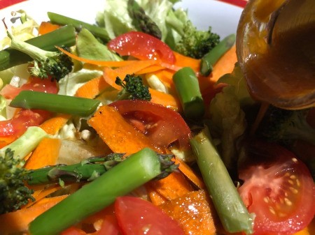 pouring dressing on salad