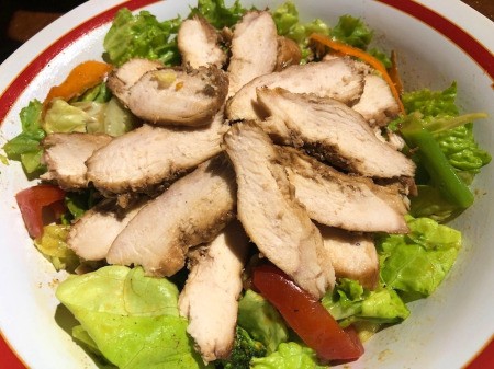 adding chicken to salad