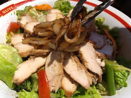 adding Caramelized Onion to Salad in bowl