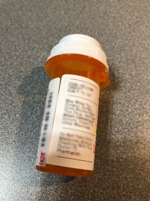 A pill bottle with the information blurred out.