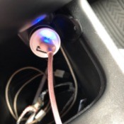 A car phone charger adapter with the light on.