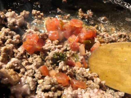 adding salsa to cooking ground beef