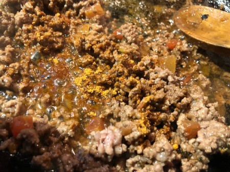 adding taco seasoning to ground beef