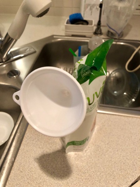 Using a funnel to fill a plastic bag.