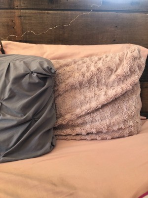 Two decorative pillows propped up on a headboard.