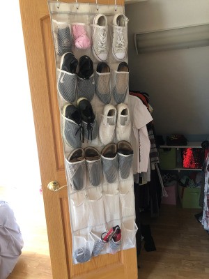 An over the door shoe organizer with shoes, socks and other accessories stored inside.