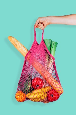 A grocery bag with fresh fruit and bread.