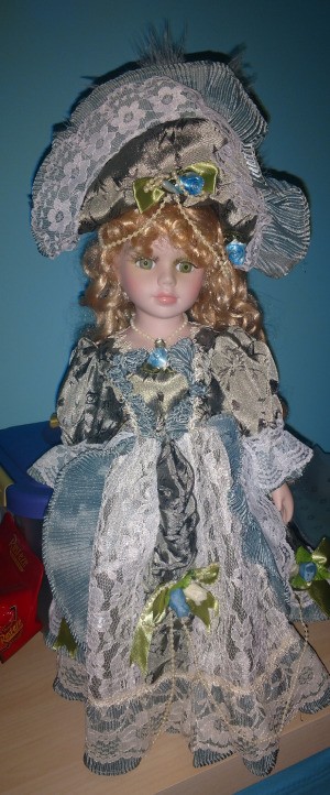 Identifying a Porcelain Doll - doll wearing a fancy blue dress trimmed with white lace