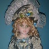 Identifying a Porcelain Doll - doll wearing a fancy blue dress trimmed with white lace