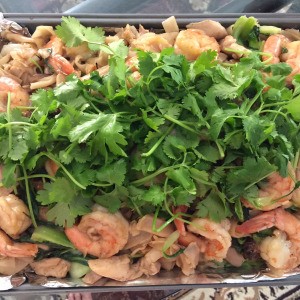 Stir Fried Flat Noodles with Chicken and Shrimp garnished with cilantro
