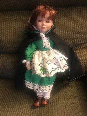 Identify and Value of a J. Misa Doll - doll wearing a green dress with a white eyelet apron and a dark cape