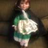 Identify and Value of a J. Misa Doll - doll wearing a green dress with a white eyelet apron and a dark cape