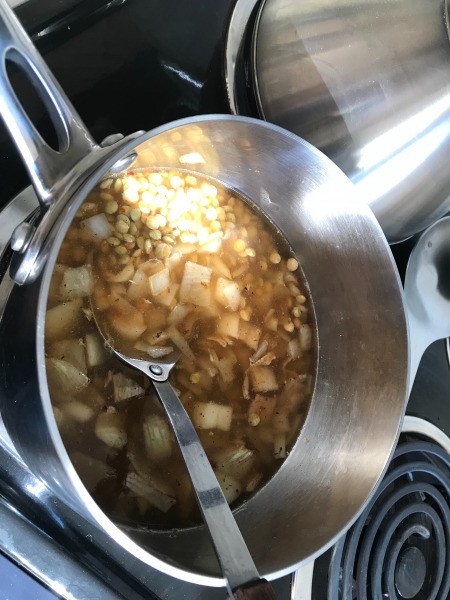 adding water and lentils to pan