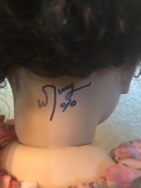 A signature on the back of a porcelain doll.