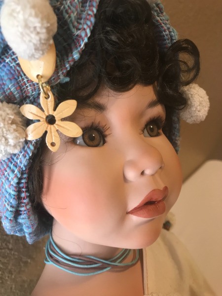 A porcelain doll wearing a hat.