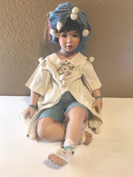 A porcelain doll in a seated pose.