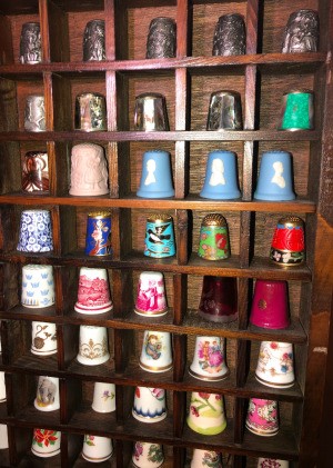 Finding the Value of Collectible Thimbles - wood rack filled with thimbles
