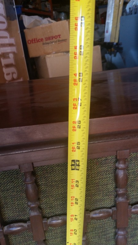 Showing the size of a console stereo cabinet with a measuring tape.