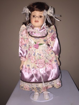 Identifying a Porcelain Doll - doll wearing a lavender dress with floral bodice, part of the sleeves, and an apron like layer