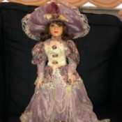 Identifying a Porcelain Doll - doll in Victorian dress of light purple and floral with matching hat