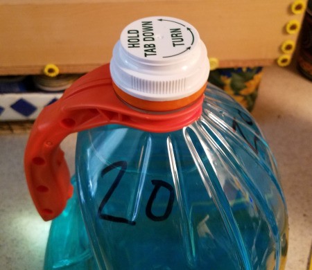A prescription bottle lid that fits on a gallon jug.