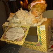 Value of a Crowne Porcelain Doll - baby doll lying on top of her box