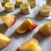 Fruit slices on parchment paper to be frozen individually.