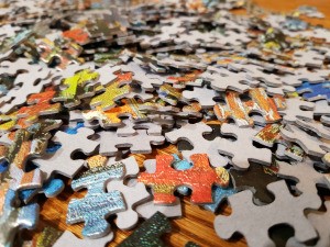 A pile of colorful cardboard puzzle pieces.