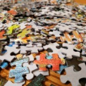 A pile of colorful cardboard puzzle pieces.