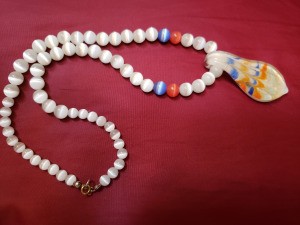 A beaded necklace with a colorful pendant.