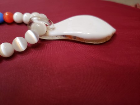A beaded necklace with a colorful pendant.