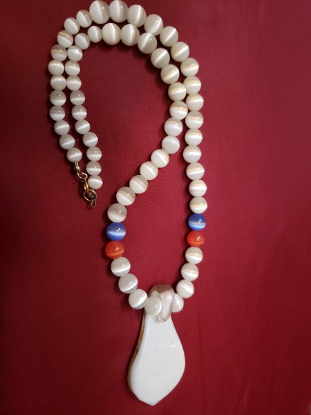 A beaded necklace with a colorful pendant.