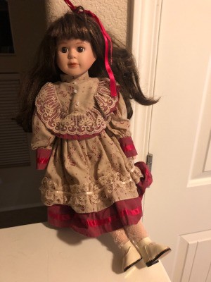 Value of a Connoisseur Collection Doll - doll wearing a red dress with lace trimmed floral bodice, sleeves, and overskirt