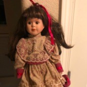 Value of a Connoisseur Collection Doll - doll wearing a red dress with lace trimmed floral bodice, sleeves, and overskirt