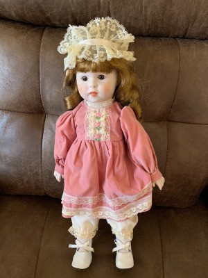 Identifying a Porcelain Doll - doll in pink dress with a lace cap