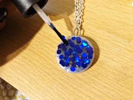 Making a Bottle Cap Glitter Pendant Necklace - seal with clear nail polish or craft sealer