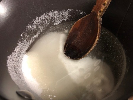 Making Rainbow Lollipops - add sugar, water, and corn syrup to pan and bring to a boil, stirring