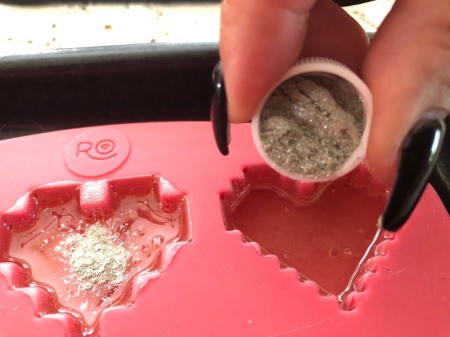 Making Rainbow Lollipops - sprinkle with the glitter and stir