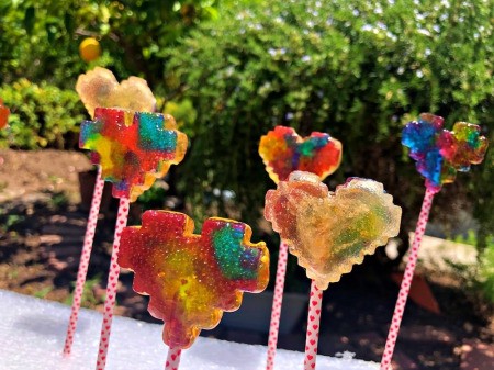Making Rainbow Lollipops - lollies on sticks stuck into a piece of white foam packaging