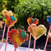 Making Rainbow Lollipops - lollies on sticks stuck into a piece of white foam packaging