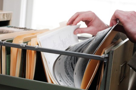 A file cabinet with manila folders and papers filed neatly.