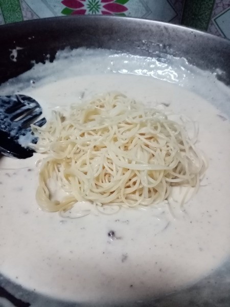 adding pasta to Carbonara sauce
